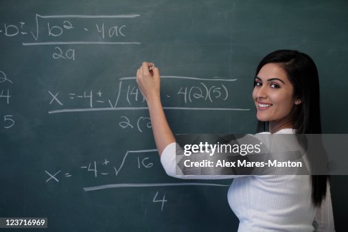 Person Writing Math Young Woman Writing Math Equation On Chalk Board And Smiling High-Res ...