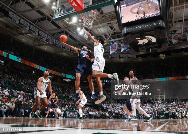 Sam Sessoms of the Penn State Nittany Lions drives to basket against Max Christie of the Michigan State Spartans in the second half at Breslin Center...