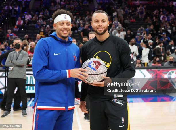 Seth Curry of the Philadelphia 76ers and Stephen Curry of the Golden State Warriors pose for a photo with an NBA 75th Anniversary basketball prior to...