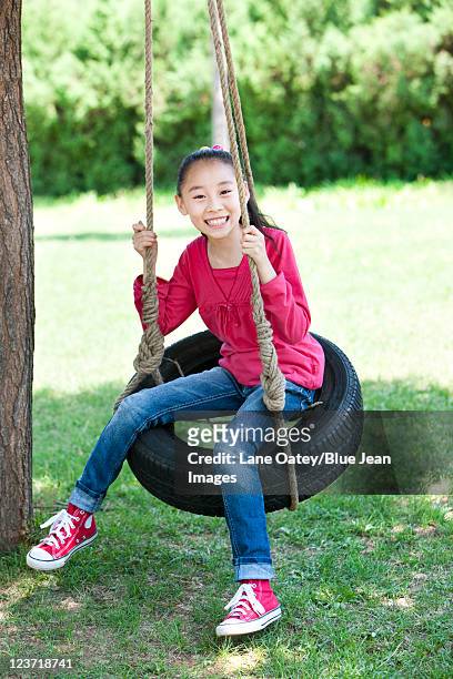 young girl swinging - tire swing stock pictures, royalty-free photos & images