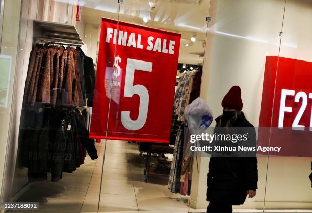 Woman walks past a discount poster at a shopping center in New York, the United States, Dec. 10, 2021. The U.S. Consumer price index CPI in November...