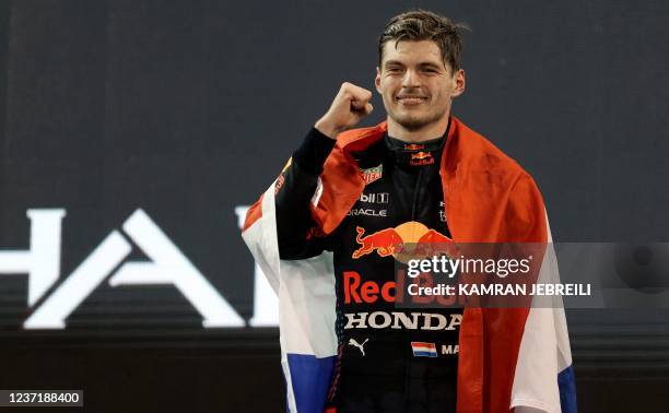 Formula One World Champion Red Bull's Dutch driver Max Verstappen celebrates on the podium of the Yas Marina Circuit after the Abu Dhabi Formula One...