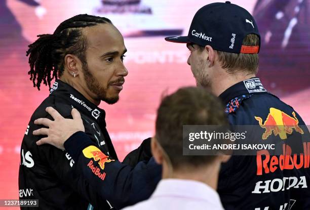 Formula One World Champion Red Bull's Dutch driver Max Verstappen greets second-placed Mercedes' British driver Lewis Hamilton after the Abu Dhabi...