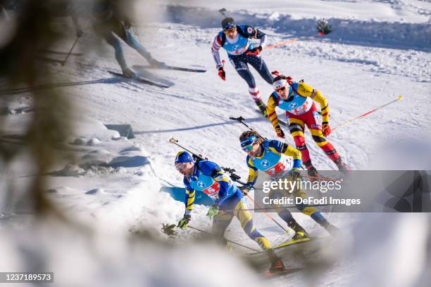 Artem Pryma of Ukraine, Peppe Femling of Sweden, Dmitrii Shamaev of Romania in action competes in the Men's 4x7.5 km Relay Competition during the BMW...