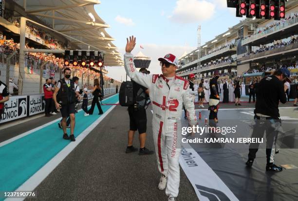 Alfa Romeo's Finnish driver Kimi Raikkonen walks on the grid of the Yas Marina Circuit before the Abu Dhabi Formula One Grand Prix on December 12,...