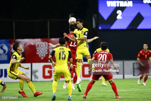 Nguyen Tien Linh of Vietnam and Baddrol Bin Bakhtiar of Malaysia compete for the ball during the AFF Suzuki Cup 2020 Group B match between Vietnam...