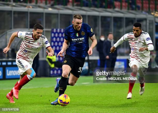 Inter Milan's Slovakian defender Milan Skriniar fights for the ball with Cagliari's Uruguayan defender Martin Caceres and Cagliari's Brazilian...