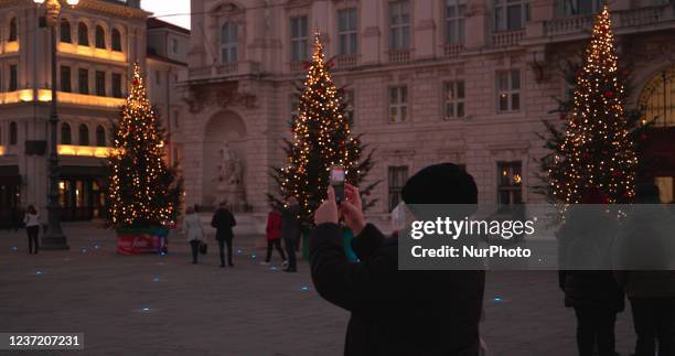 Woman takes a picture of the Plaza Unidad de Italia in Trieste, Italy, on December 12, 2021.