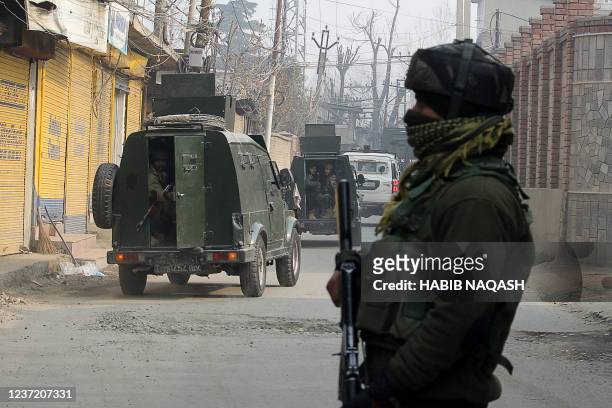 Indian Army soldiers stand guard on the outskirts of Srinagar on December 13 after two suspected militants were killed in a gunfight with security...