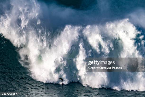 Big wave surfer Justine Dupont of France rides a wave during the TUDOR Nazare Tow Surfing Challenge at Praia do Norte on December 13, 2021 in Nazare,...