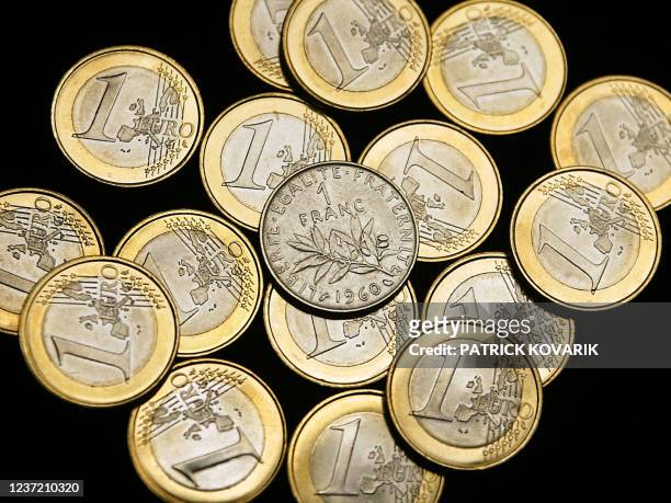 Vue, prise le 31 décembre 2001 à Paris, de pièces en euros avec, au centre, une pièce d'un franc, monnaie vieille de 641 ans qui disparaît avec...