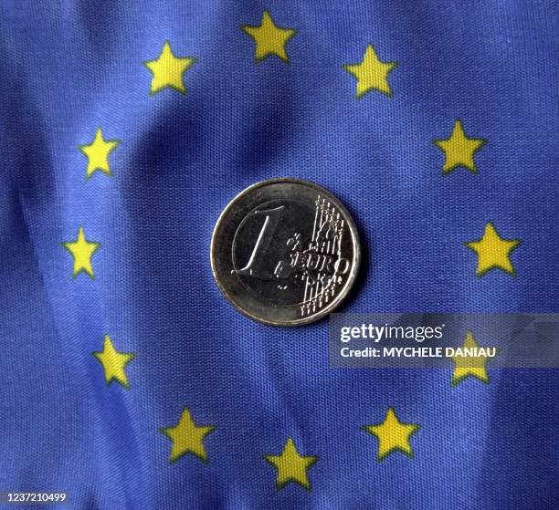 Photo prise le 19 décembre 2001 d'une pièce d'un euro sur fond de drapeau européen. AFP PHOTO MYCHELE DANIAU