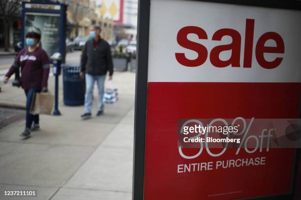 Shoppers walk past a "Sale" sign outside the Easton Town Center shopping mall in Columbus, Ohio, U.S., on Friday, Dec. 10, 2021. Prices for popular...