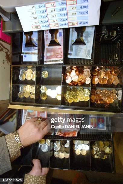 Une caissière s'aide d'un tiroir-caisse double, un pour le franc, un pour l'euro, dans une patisserie parisienne, le 02 janvier 2002, au premier jour...