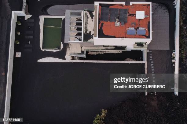 This aerial picture shows a house covered with lava and ashes following the eruption of the Cumbre Vieja volcano, in Las Norias, on the Canary Island...