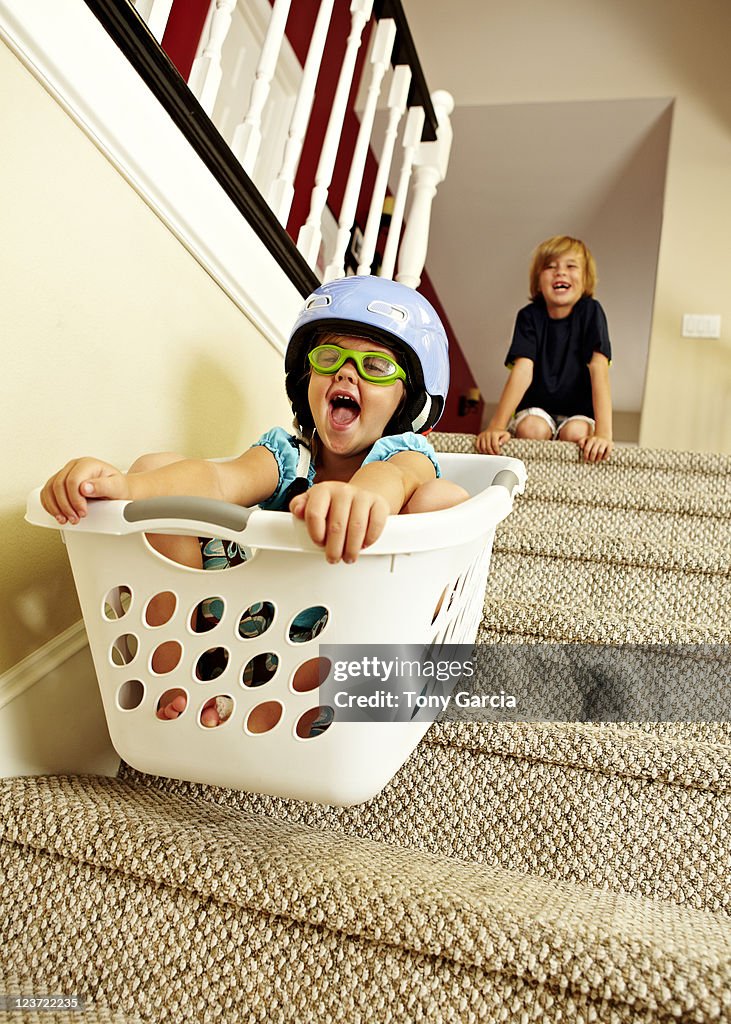 Girl going downstairs in a laundry basket.