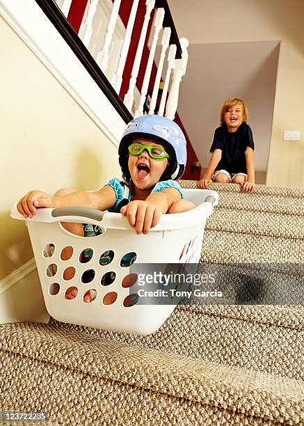 girl going downstairs in a laundry basket. - children misbehaving stock pictures, royalty-free photos & images
