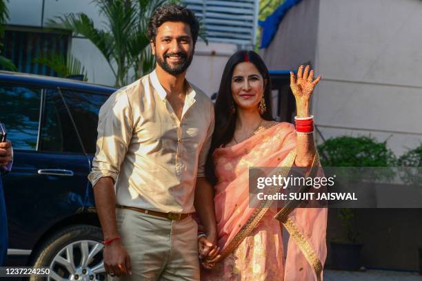 Newlywed Bollywood actors Vicky Kaushal and Katrina Kaif pose outside an airport upon their return in Mumbai on December 14, 2021.