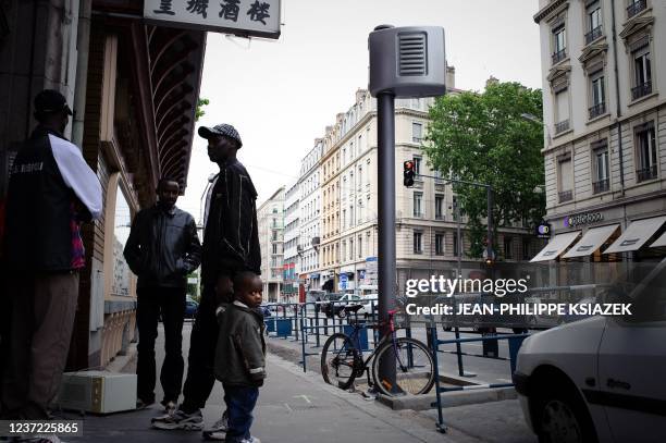 Des personnes discutent, le 11 mai 2009, près d'un radar détecteur d'infractions au feu rouge installé dans le centre de Lyon pour une série de...