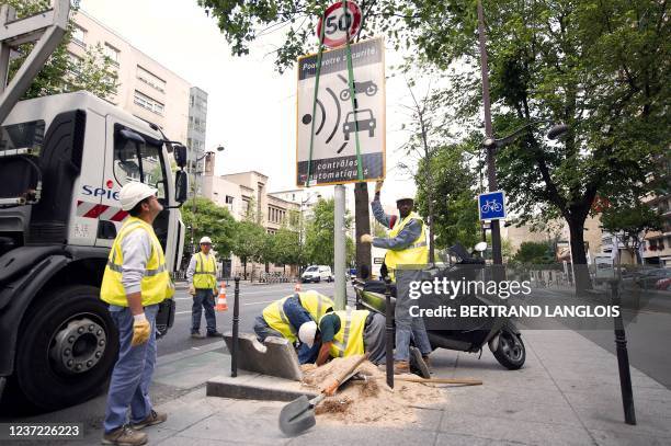 Des ouvriers de la société de services Spie démontent un panneau avertissant de la présence d'un radar, le 16 mai 2011 à Paris, le premier de la...