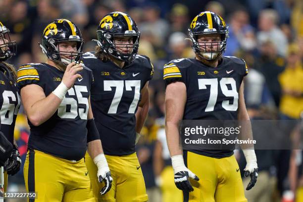 Iowa Hawkeyes offensive linemen Tyler Linderbaum , Connor Colby and Jack Plumb look on during the Big Ten Championship Game between the Iowa Hawkeyes...