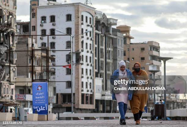 Women walk along the promenade overlooking the Mediterranean sea waterfront in Libya's eastern second city of Benghazi on December 14, 2021.