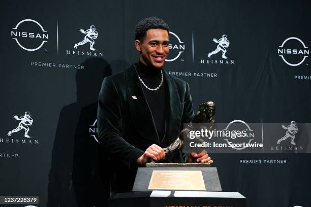 Alabama quarterback Bryce Young poises for photos with the trophy after winning the Heisman Trophy at the press conference at the Marriott Marquis in...