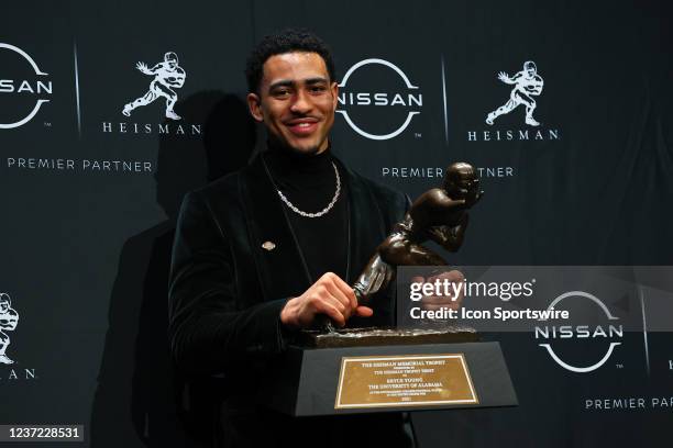 Alabama quarterback Bryce Young poises for photos with the trophy after winning the Heisman Trophy at the press conference at the Marriott Marquis in...