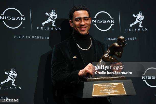 Alabama quarterback Bryce Young poises for photos with the trophy after winning the Heisman Trophy at the press conference at the Marriott Marquis in...