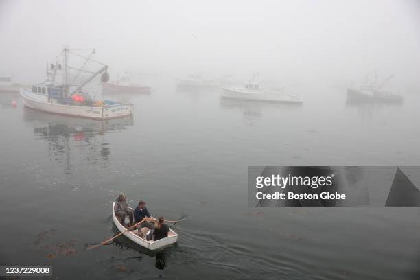 Crew rows out to their boat on a foggy morning in Vinalhaven, ME on July 26, 2021. The plentiful catch that brought wealth to fishing families is at...