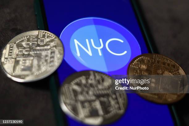 NewYorkCoin logo displayed on a phone screen and representation of cryptocurrency are seen in this illustration photo taken in Krakow, Poland on...