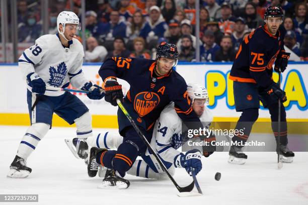 Darnell Nurse of the Edmonton Oilers battles against Auston Matthews of the Toronto Maple Leafs during the first period at Rogers Place on December...
