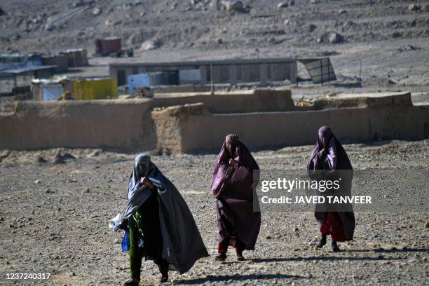 Women wearing a burqa arrive to collect food aid distributed by the Red Cross in Kandahar on December 15, 2021.