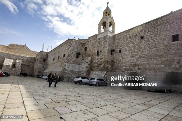 Two women walk in the empty Manger Square outside the Church of the Nativity, traditionally believed to be the birthplace of Christ, in the biblical...