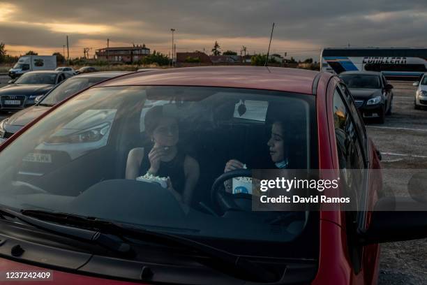 Customers eat popcorn in their car as they wait to watch 'Joker' movie from their car at a temporary drive-in theatre held in a disco club car park...