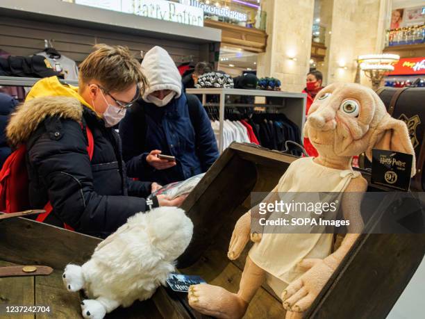 Dobby stuffed-toy is seen displayed in a box as two young shoppers check on some Harry Potter merchandise at Central Children's Store. Harry Potter...