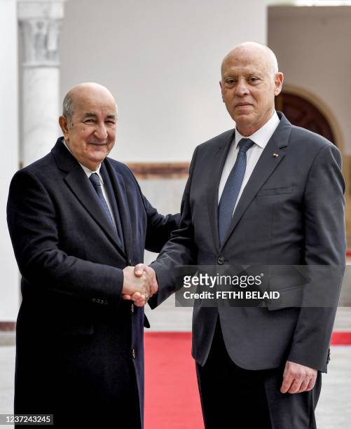 Tunisia's President Kais Saied shakes hands with Algeria's President Abdelmajid Tebboune as the latter arrives at Tunis-Carthage International...