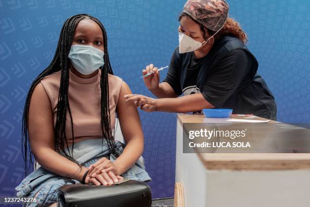 Woman receives a dose of the Pfizer/BioNTech vaccine against COVID-19 at Discovery vaccination site in Sandton, Johannesburg, on December 15, 2021. -...