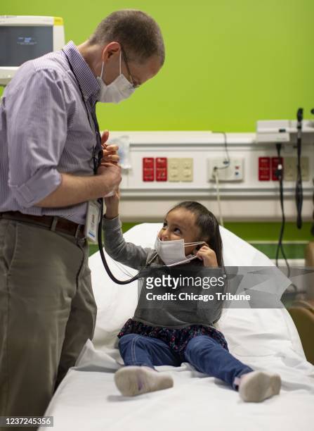 Elena Rosales prueba el estetoscopio con el Dr. Bill Muller mientras se realiza un chequeo en el Lurie Children&apos;s Hospital el 7 de diciembre de...