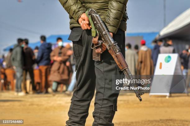 Police Cop holds an AK-47 assault rifle as he stands guard during Jashn-e-Chillai Kalan at Shopian, Jammu and Kashmir, India on 15 December 2021.