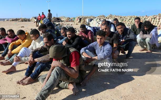 Migrants rescued by Tunisia's national guard during an attempted crossing of the Mediterranean by boat, rest on the beach at the port of el-Ketef in...