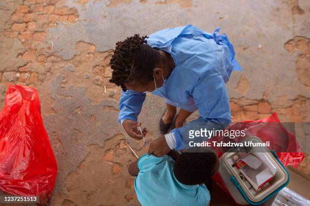 Nurse administers Covid 19 vaccine on a teenager at a School near Banket on December 15, 2021 in Chinhoyi, Zimbabwe. The country has extended a...