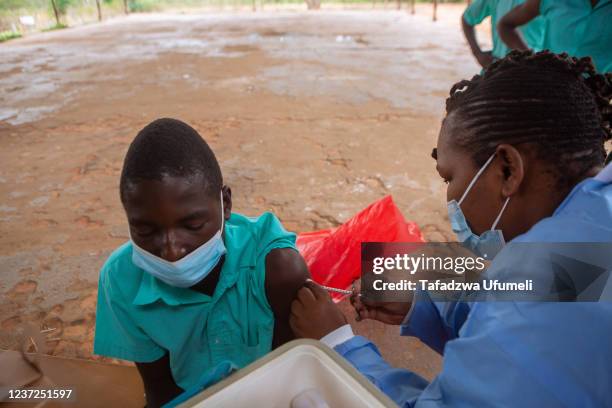 Teenager at Riverside Secondary School near Banket, gets his first jab of the Covid 19 vaccine on December 15, 2021 in Chinhoyi, Zimbabwe. The...