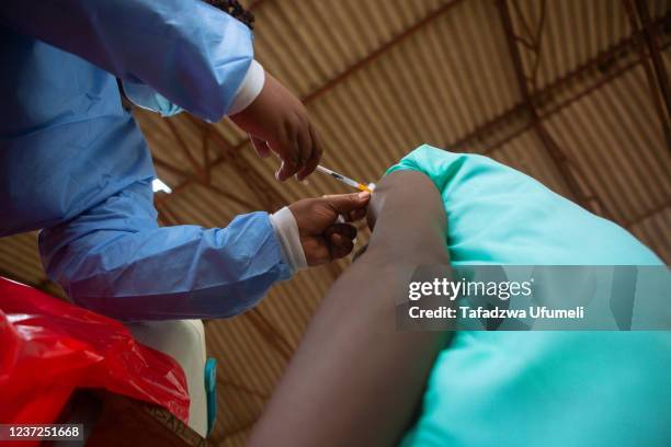 Teenager at Riverside Secondary School near Banket, gets his first jab of the Covid 19 vaccine on December 15, 2021 in Chinhoyi, Zimbabwe. The...