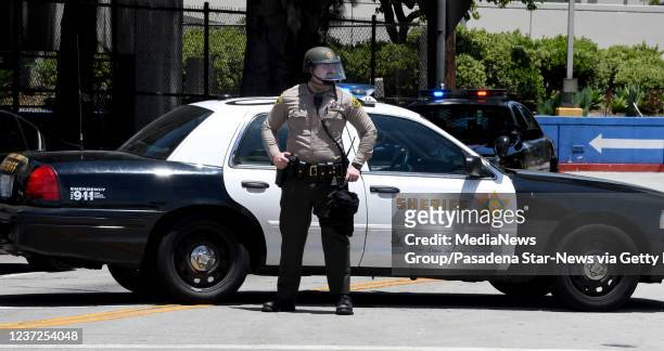 Los Angeles County Sheriff Deputy stands guard as the National Alliance against racist and political repression protest in front of the men"u2019s...