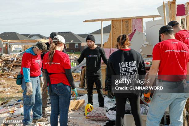 Clarksville, Tennessee church group members pray as they clean up what is left of a home where they stand, in Bowling Green, Kentucky on December 15...