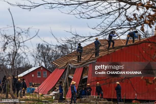 Members of the Amish community repair a destroyed barn in Fulgham, Kentucky, on December 15 five days after tornadoes hit the area. - As the US...