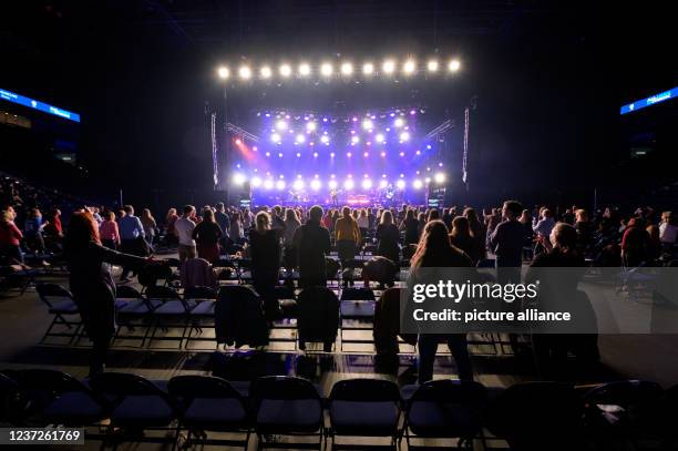 December 2021, Hamburg: The audience dances with distance at the seats in front of the stage during the performance of the band Revolverheld....