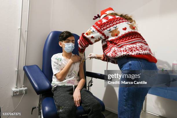 Nurse vaccinates a child, on the first day of vaccination in Italy for children aged 5 to 11, inside a room of the vaccination center set up to...