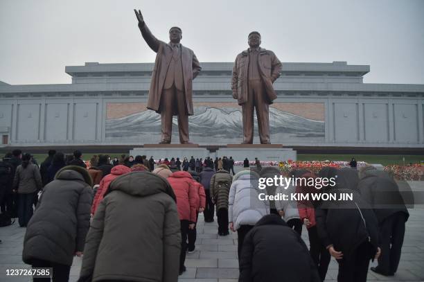 People bow as they pay their respects before the statues of late North Korean leaders Kim Il Sung and Kim Jong Il to mark the ten year anniversary of...